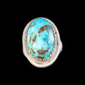 Turquoise ring with silver band on a black background