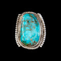 Turquoise ring with silver band on a black background
