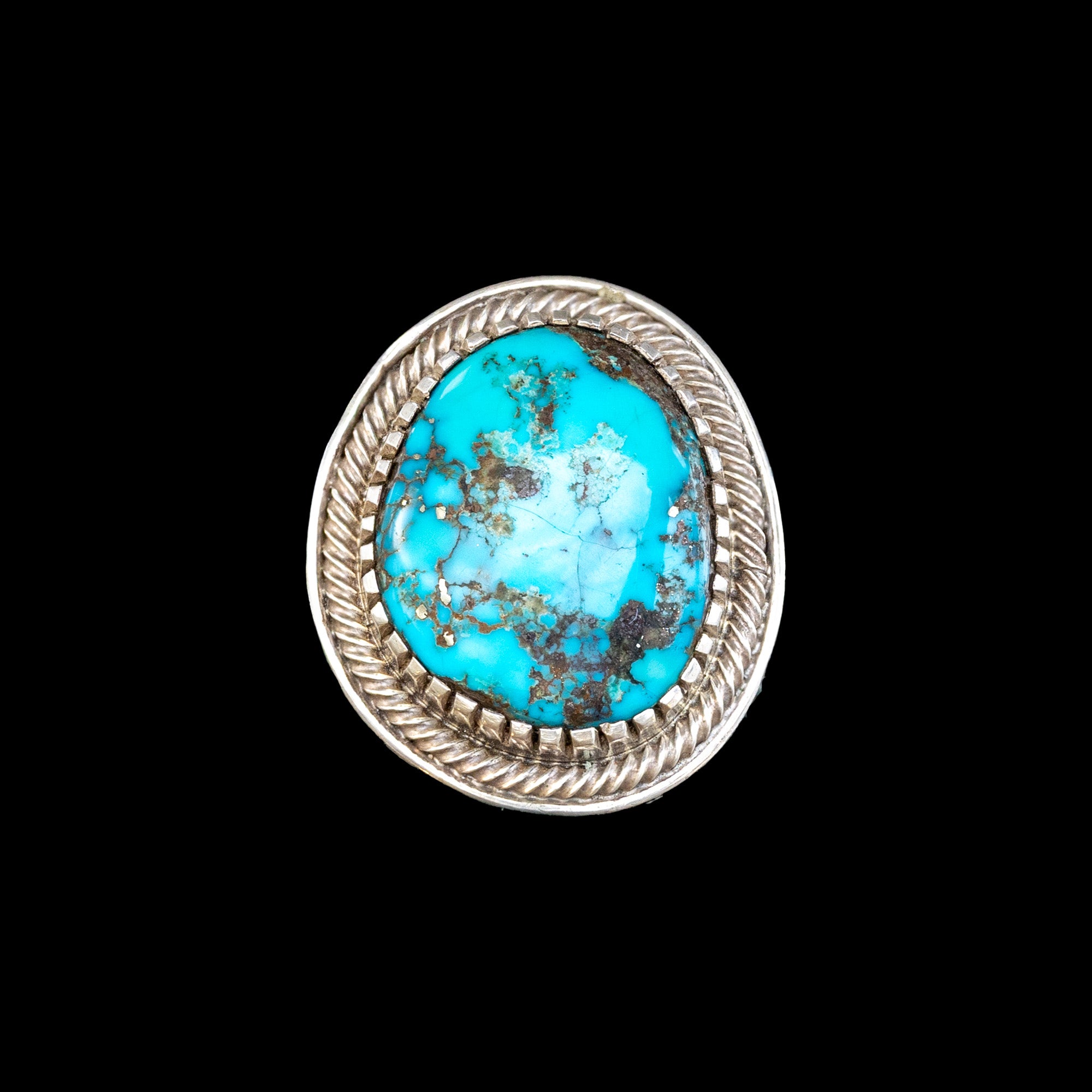 Turquoise stone ring with silver band on a black background