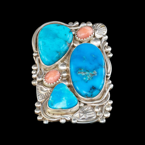 Silver ring with turquoise and coral stones on a black background
