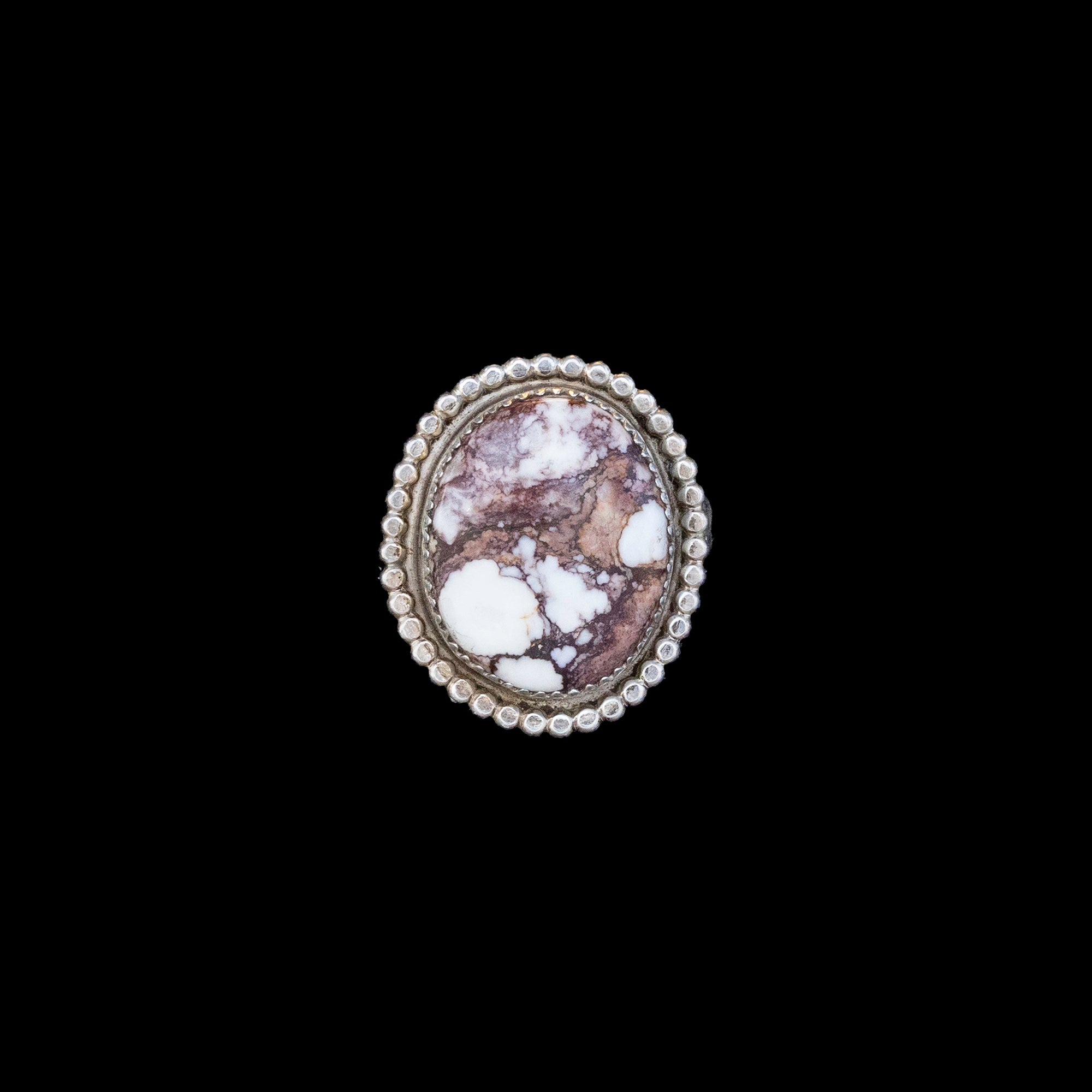 Sterling silver ring with a white buffalo stone design on a black background