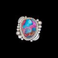 Silver ring with a colorful stone on a black background