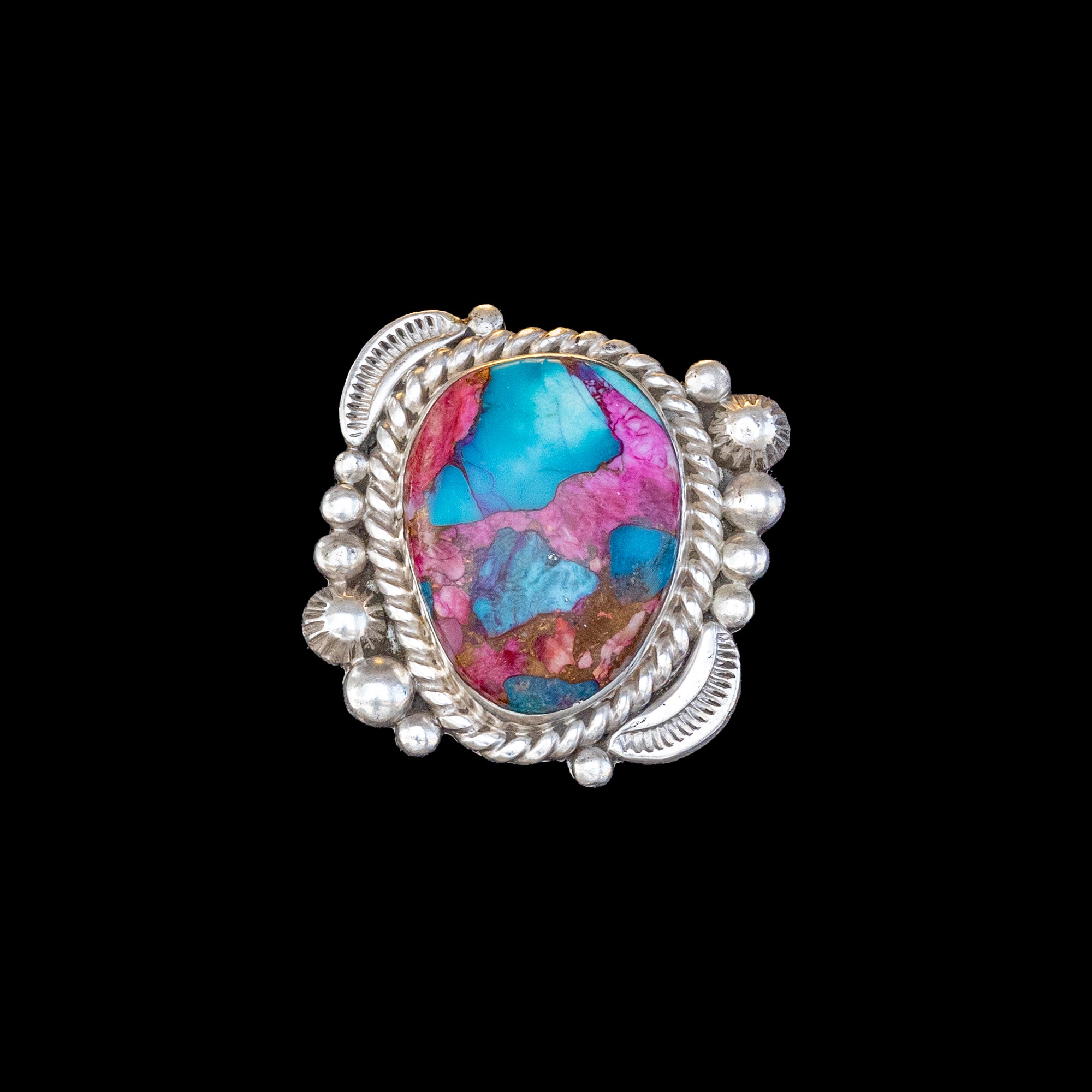 Silver ring with a colorful stone on a black background