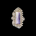 Silver ring with a purple and white shell on a black background