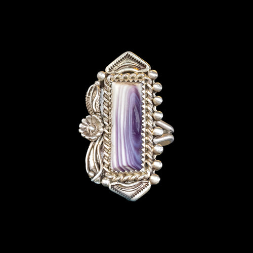 Silver ring with a purple and white shell on a black background