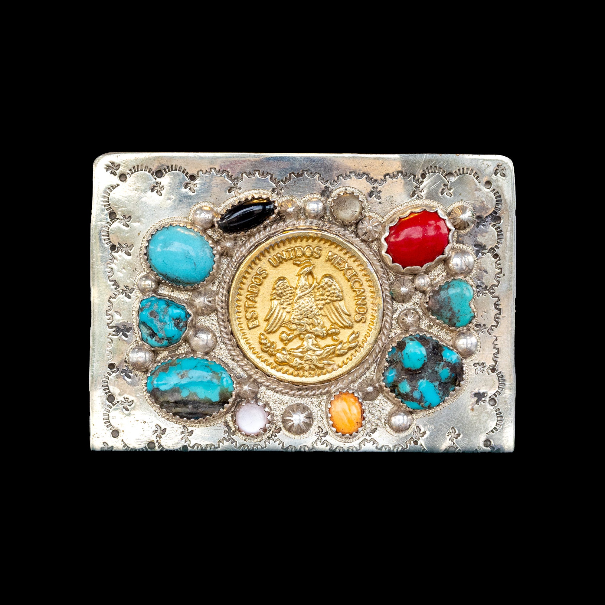Decorative belt buckle with gold coin, colored stones, and silver embellishments on a black background