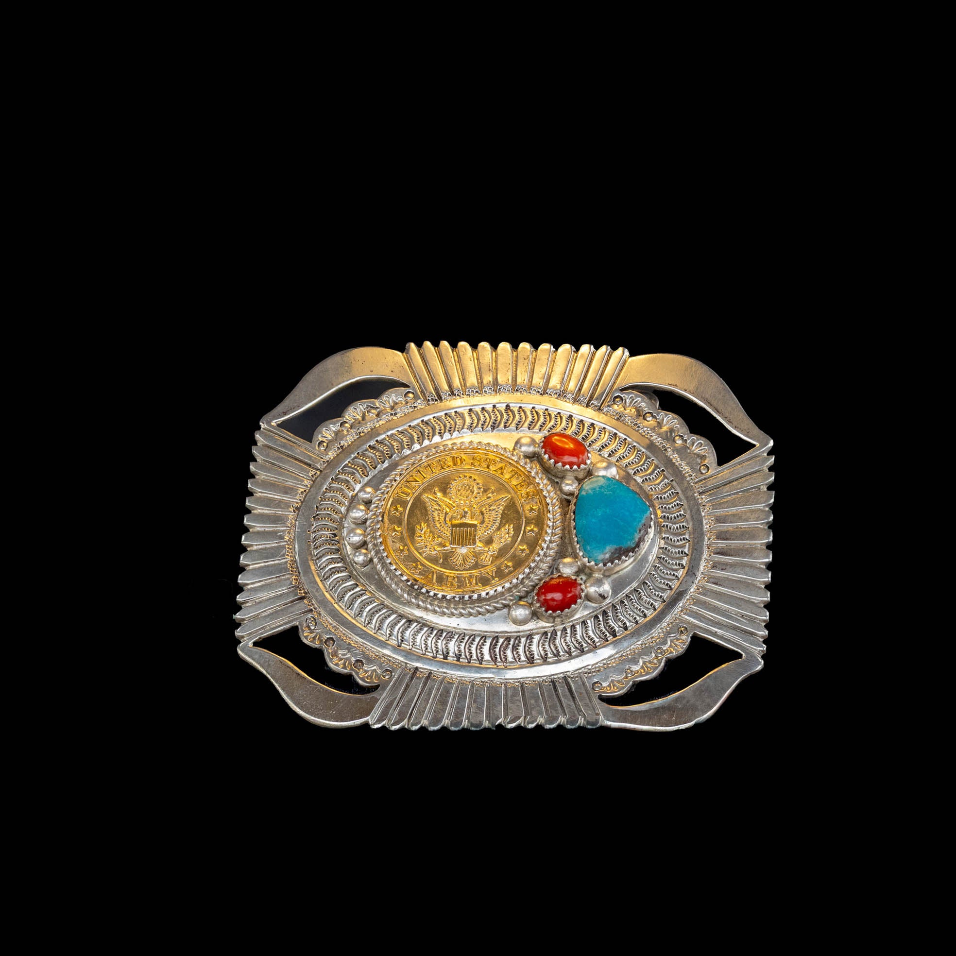 Decorative belt buckle with gold, silver, red, and blue stones on a black background
