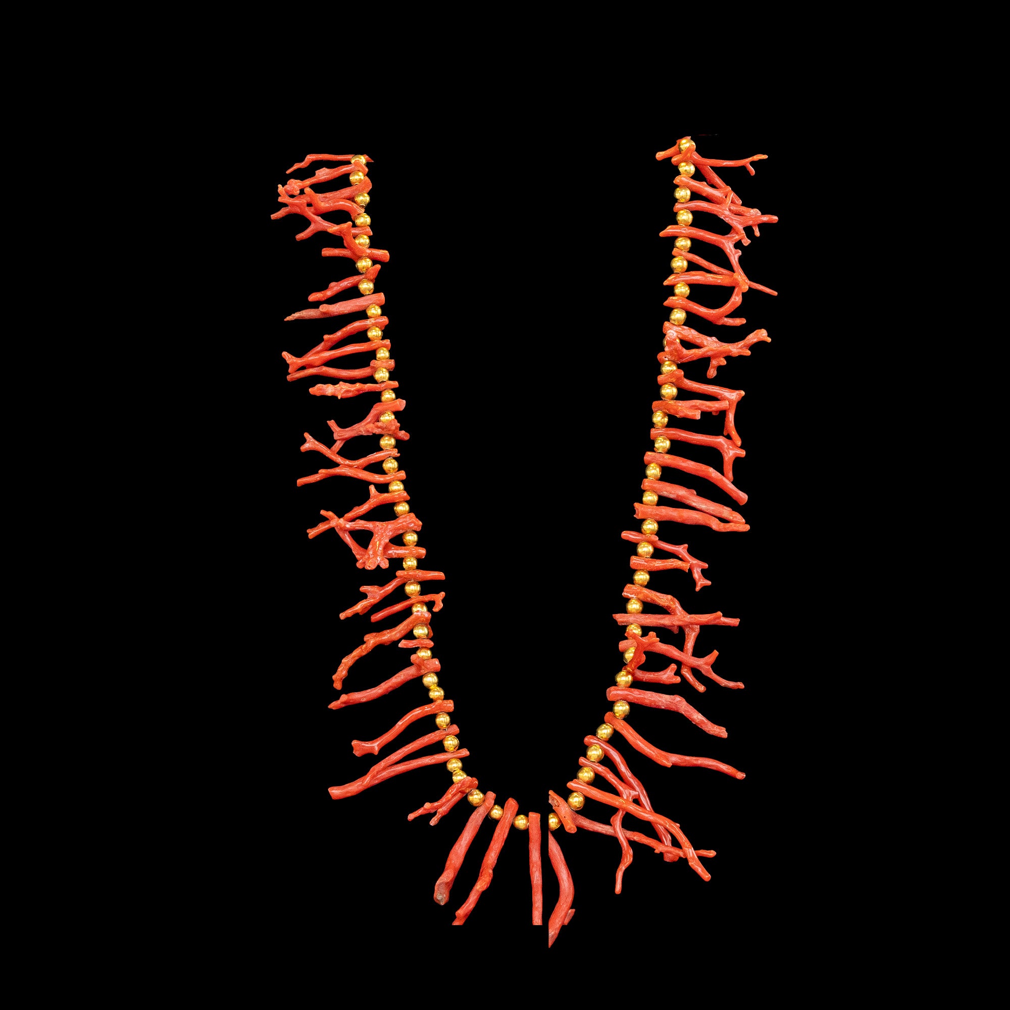 Necklace with coral and gold plated beads on a black background