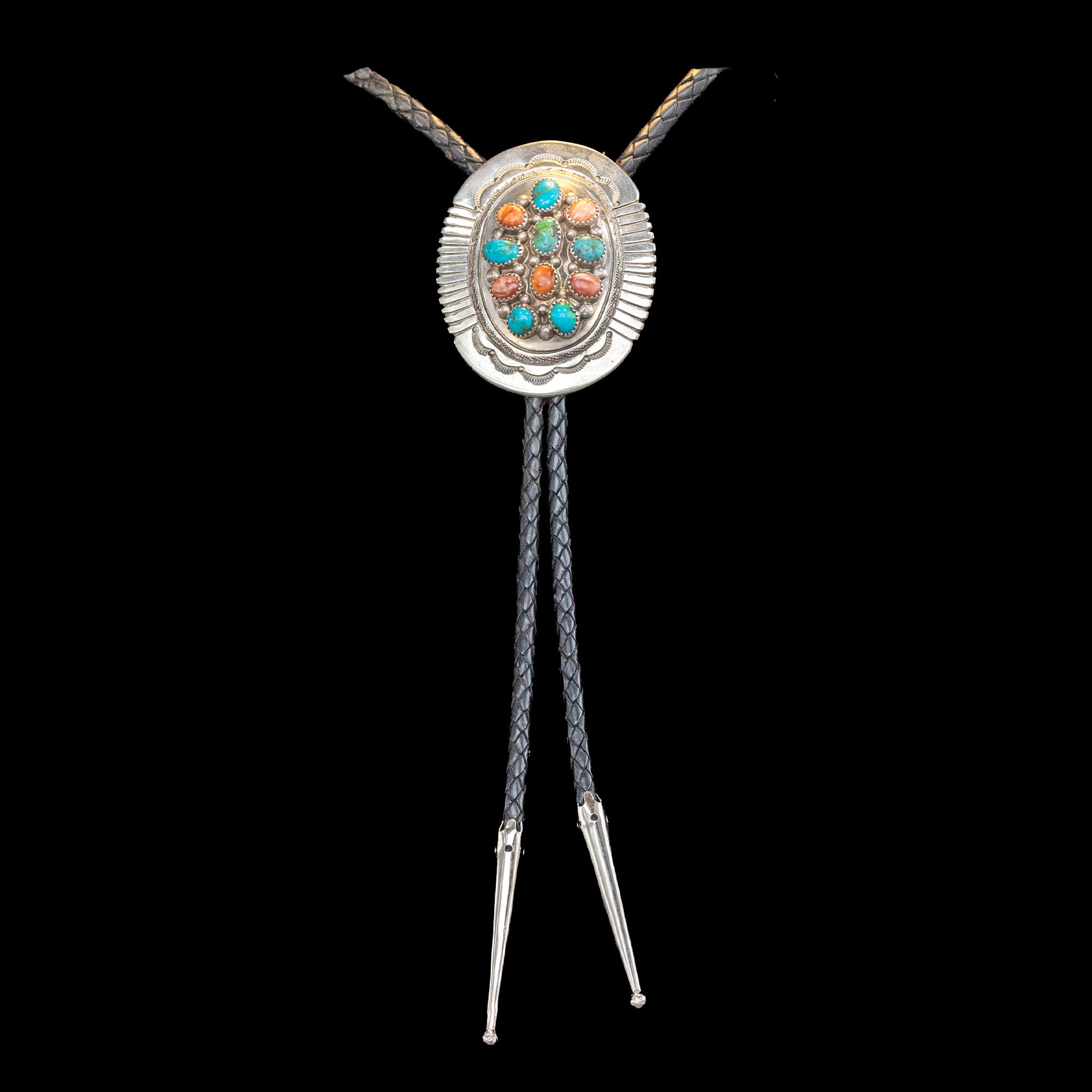 Silver bolo tie with turquoise, coral and shell on a black background