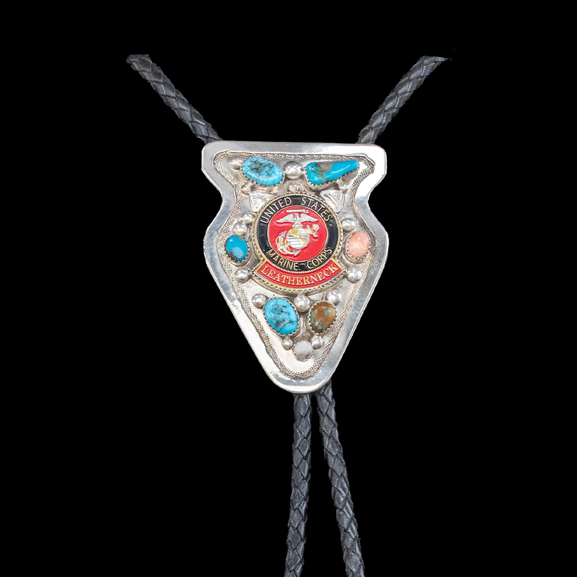 Bolo tie with United States Marine Corps emblem and gemstones on a black background