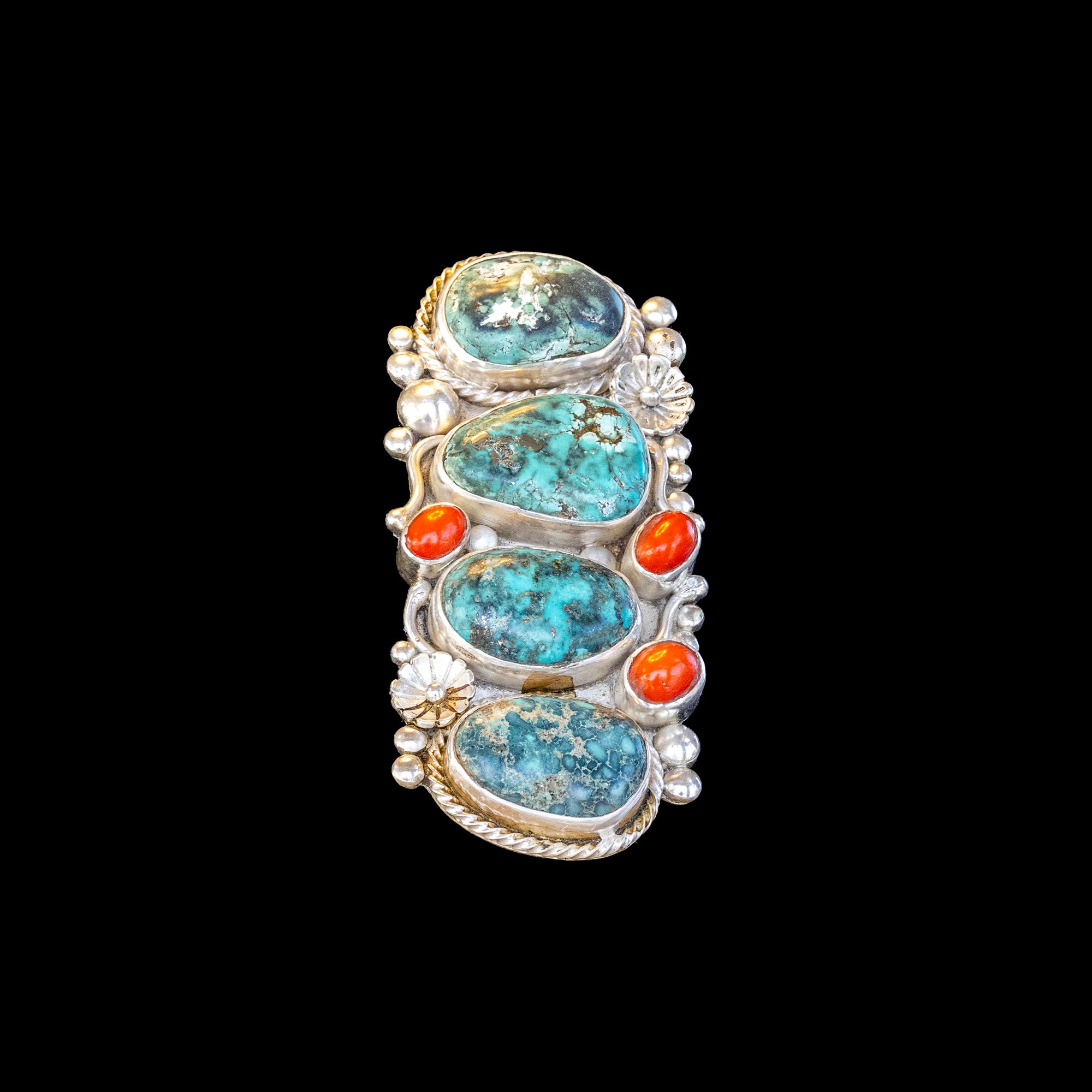 Ring with turquoise, coral and silver accents on a black background