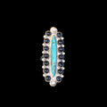 Ring with blue central stone and black stones on a black background