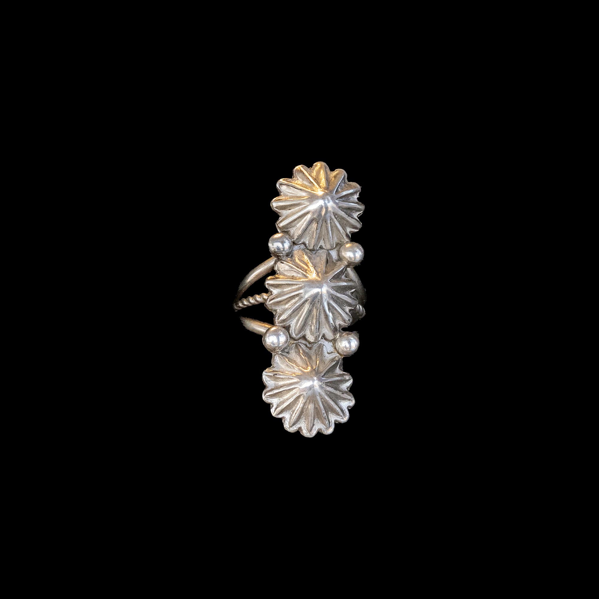 Silver floral ring on a black background