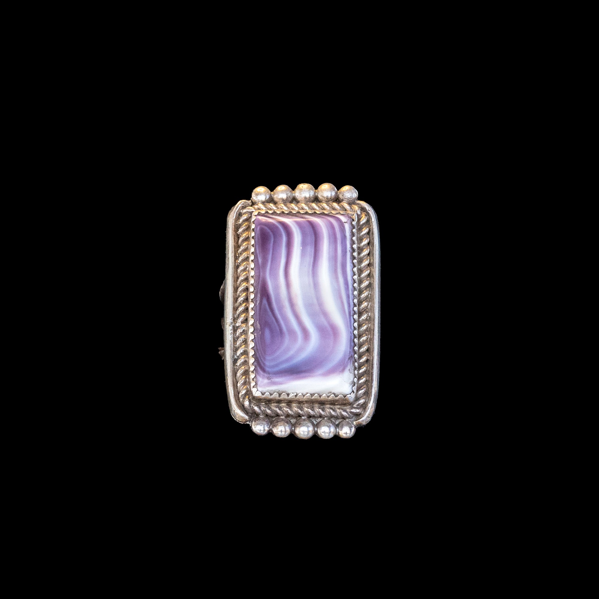 Ring with purple wampum shell and silver band on black background