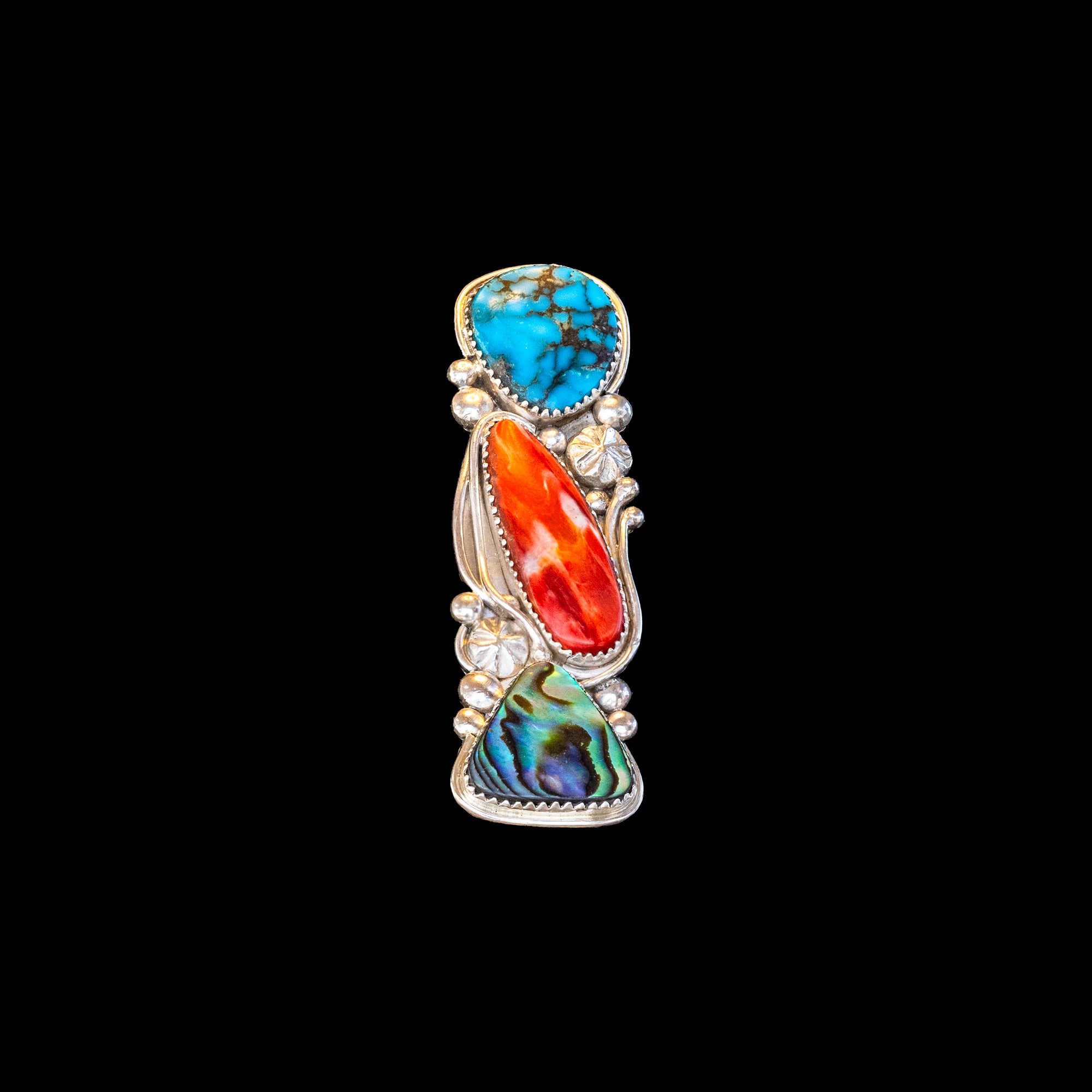 Ring with turquoise, shell, and coral on a black background
