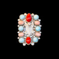 Ring with colorful stones and coral on a black background
