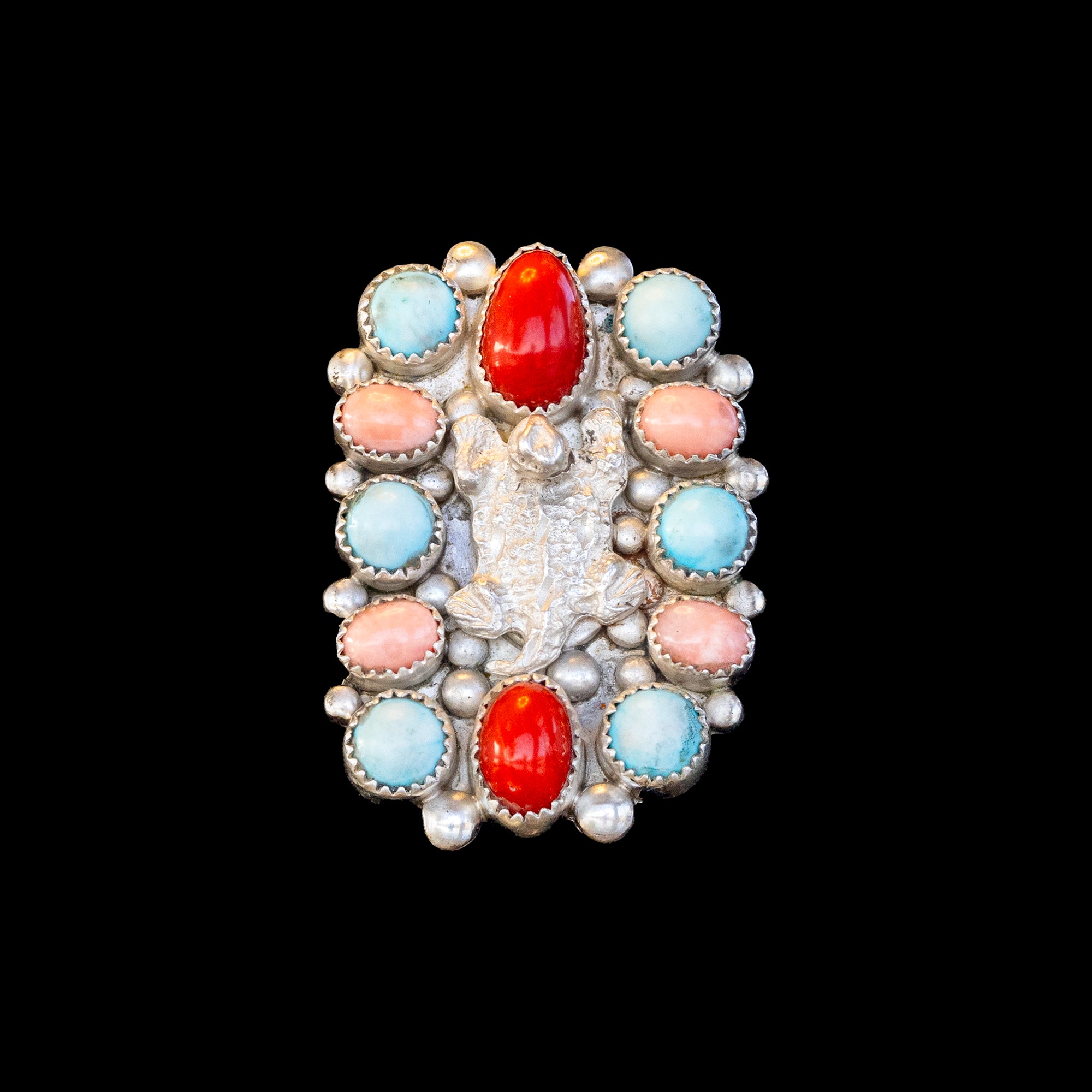 Ring with colorful stones and coral on a black background