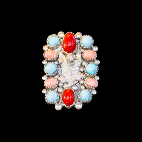 Ring with colorful stones and coral on a black background