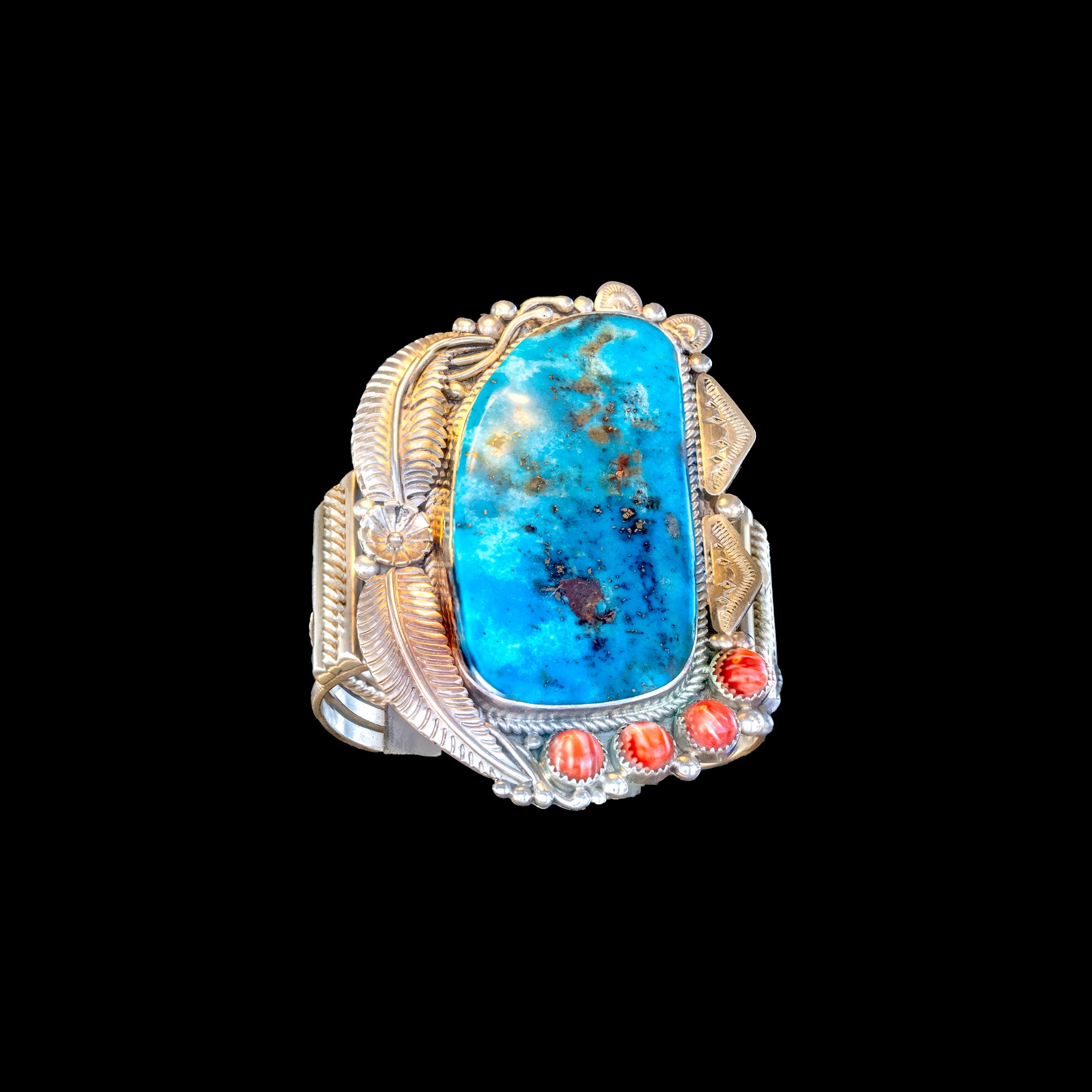 Large bracelet with turquoise stone and oyster accents on a black background