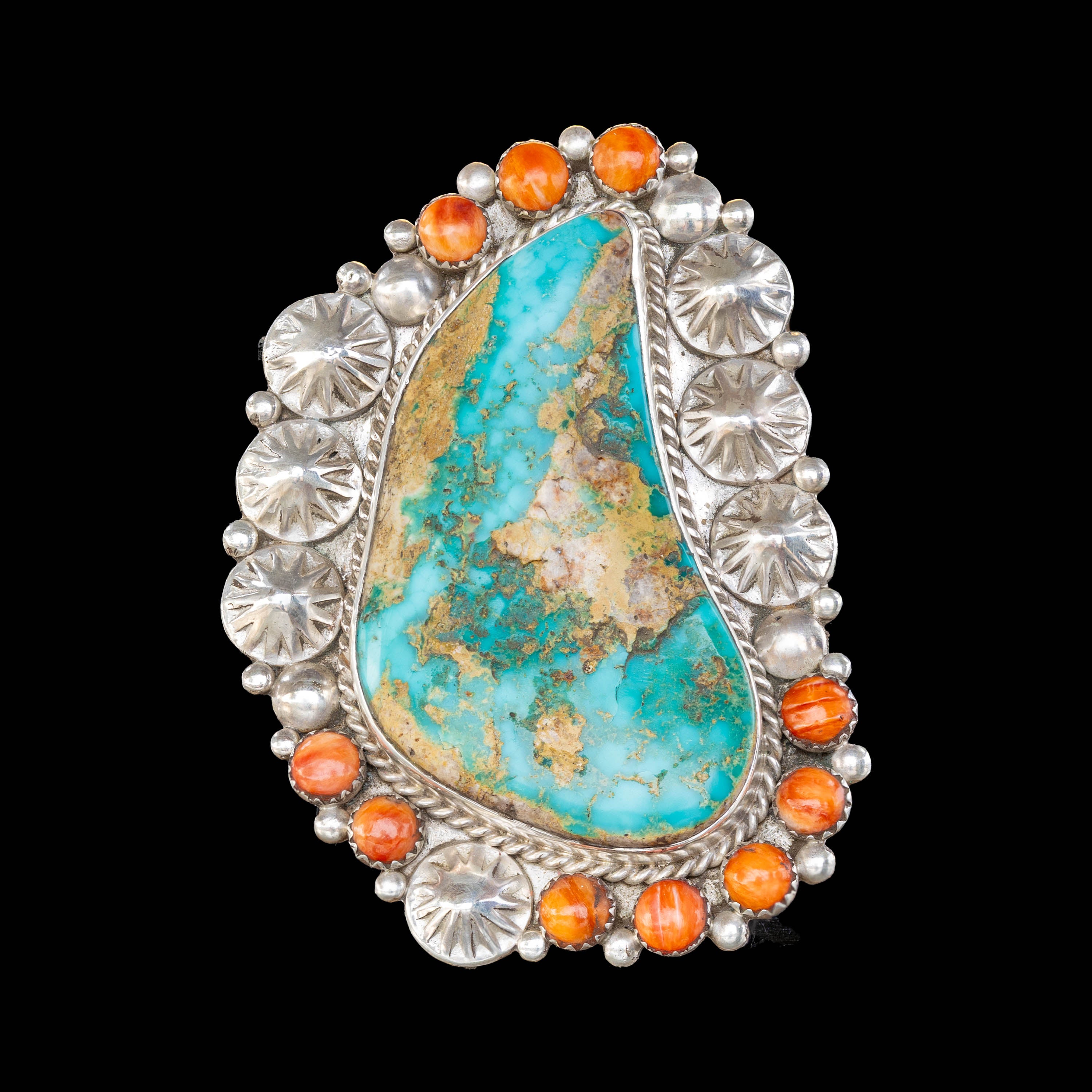 Ring with turquoise stone and orange accents on a black background