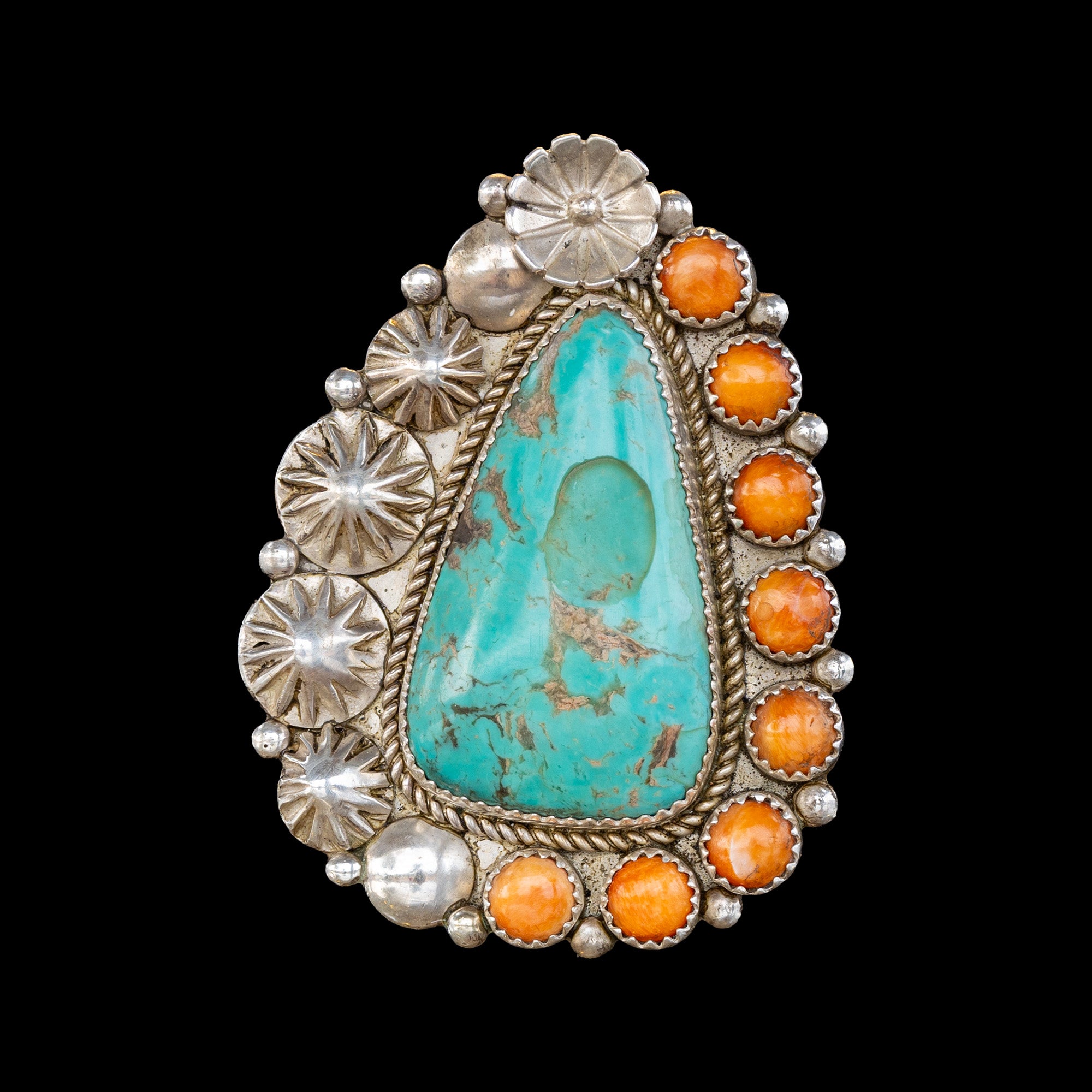 Turquoise and orange oyster ring with silver detailing on a black background